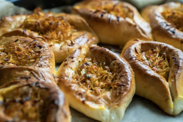 Annem evde yemek pişiriyor. Lahanalı çörekler fırın tepsisinde.