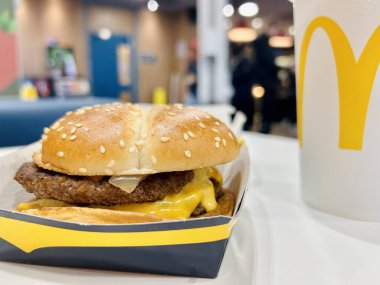 Philly Cheese Stack Burger McDonald 'da bir içkiyle.