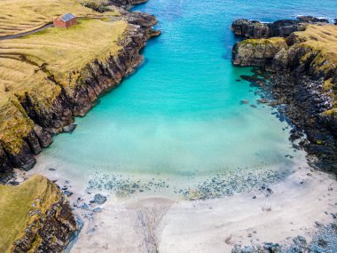 Aerial drone view of Port of Stoth on the Isle of Lewis. Turquoise water surrounded by outcrops and cliffs of surrounding cove in Outer Hebrides clipart