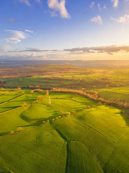 Aerial vertical view of Baildon Moor in Yorkshire countryside near Leeds. Sunset landscape with green fields.