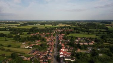 Büyük Ouseburn, Kuzey Yorkshire üzerinde uçan hava manzaralı, kırmızı tuğlalı evler ve kilise. Yüksek kalite 4k görüntü