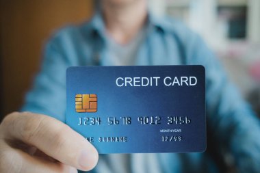 Kapat, Adam dizüstü bilgisayar kullanırken kredi kartı tutuyor, internetten alışveriş yapıyor, internetten alışveriş yapıyor. E-ticaret e-bankacılık servisi. Bilgisayarda çalışan başarılı bir serbest yazar. Çevrimiçi güvenli ödeme.