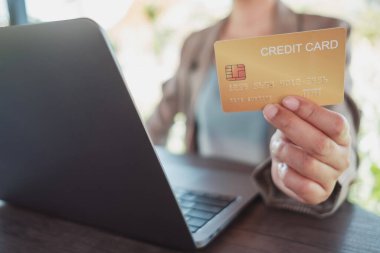Kredi kartı ve akıllı telefon tutan kadınların ellerini kapat dizüstü bilgisayar kullanan ve kahve dükkanında alışveriş yapan kadınların kredi kartlarını tut. İnternetten alışveriş, internetten alışveriş, e-ticaret e-bankacılık hizmeti. Güvenli ödeme