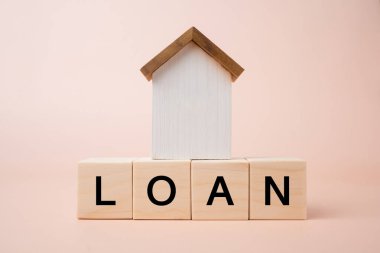 Ev kredileri ve emlak işi. Tahta küpte ahşap ev modeli. Emlak yatırımı için bankadan ipotek. Emlak piyasası konseptini alıp satmak.