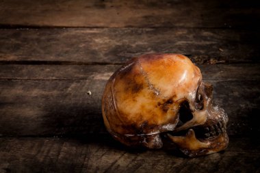 Eski ahşap arka planda insan kafatası.