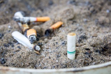 kirli bir kül tablası içinde sigara füme