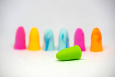 Kopyalama metni için alanı olan beyaz arkaplanda izole edilmiş renkli kulak tıkaçlarının yakın plan görüntüsü