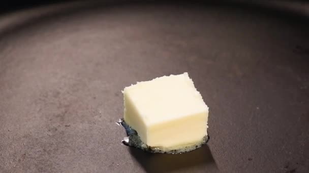 黒鋳鉄製の鍋に溶かしたバターの部分のクローズアップ 料理とフライパンの概念 — ストック動画