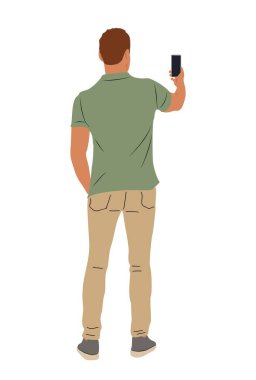 Yeşil gömlekli ve kahverengi pantolonlu bir adam cep telefonuyla fotoğraf çekiyor. Rahatlık ve rahatlık kavramı. Adam sadece anın tadını çıkarıyor ve telefonuyla yakalıyor.