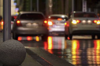 Otopark, acil durum ışıkları. Şehrin gece lambaları, araba farları. Akşamları şehir hayatı, yağmur. Odaklanamayan soyut arkaplan