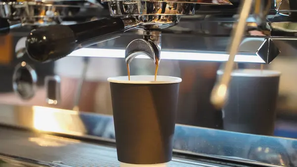 新鲜的浓缩咖啡将咖啡机中的咖啡倒入纸杯的特写 酒吧里的真实场景咖啡文化和专业咖啡制作 饮食业概念 — 图库照片