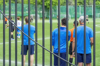 Futbol takımı futbol antrenörleri, futbol antrenmanları, arka görüş, seçici odaklanma.