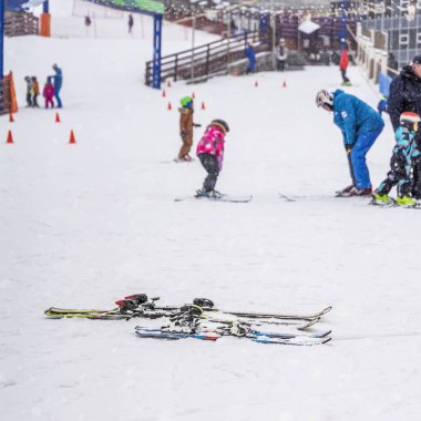 Kayak merkezinin ve çocukların spor okulunun soyut görüntüsü bulanık. Kış tatili, tatil, kış mevsimi ve etkinlik kavramı. Öndeki spor malzemelerine odaklan.