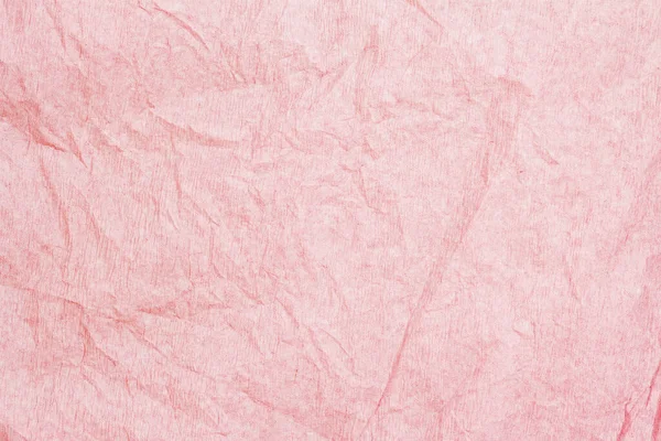 Crumpled pink crepe paper texture closeup, pastel background