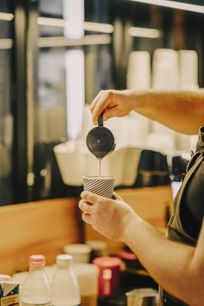 专业的咖啡师将蒸牛奶倒入咖啡纸杯 在咖啡店里做卡布奇诺咖啡 — 图库照片