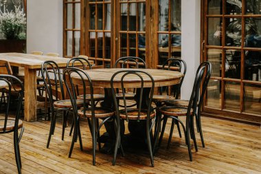 Yuvarlak, boş ahşap masa ve odada buluşmak için eski sandalyeler, klasik tarz.