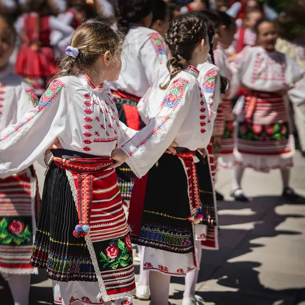 Geleneksel kostümlü kızlar Bulgar halk dansları yapıyor, yaz güneşli bir gün.