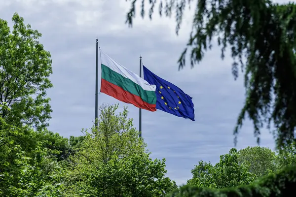 Bulgaristan ve Avrupa Birliği 'nin bayraklarını mavi gökyüzü ve yeşil manzaraya karşı sallıyor