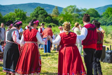 Halk dansı yapan insanlar. Bulgaristan 'da Gül Vadisi Geleneksel Festivali, gül yağı üretim alanı, Bulgar kostümleri, folklor ve kültür