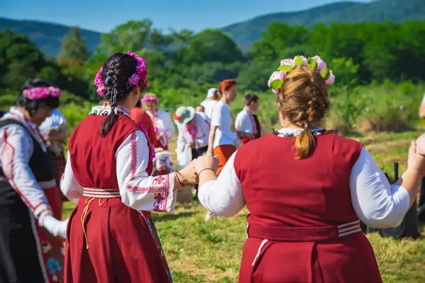İnsanlar geleneksel kıyafetler içinde şarkı söyleyip dans ediyorlar. Bulgaristan 'da yıllık rosa hasarı, toplama ritüeli