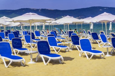 Plaj Sandalyeleri ve Şemsiyeler Güneşli yaz gününde