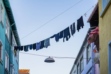 Açık mavi gökyüzü altındaki renkli binalar arasında çamaşır ipinde asılı basit ve büyüleyici şehir manzarası