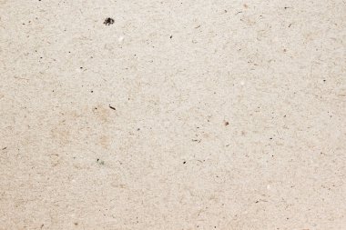 Açık kahverengi desenli kağıt yüzeyi, küçük noktalar ve liflerle yakın plan, doğal arkaplan