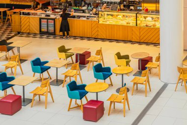 Renkli sandalyeleri, masaları ve parlak, davetkar bir tasarımı olan boş modern kafe manzarası