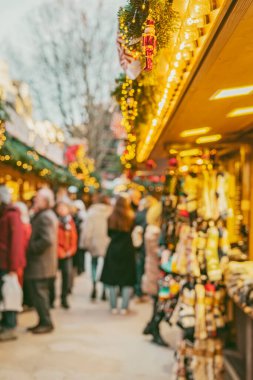 Parlayan ışıkları, ahşap tezgahları ve şenlikli dekorasyonları olan bulanık bir tatil pazarı.
