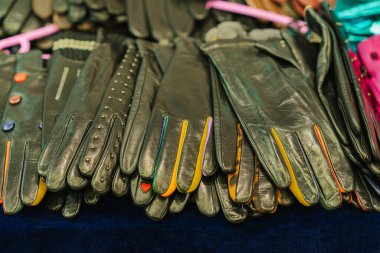 Renkli detaylarıyla sergilenen siyah deri eldivenler. Tarz ve zanaat kavramı