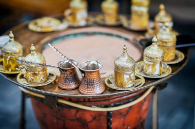 Geleneksel Türk kahvesi seti, süslü altın bardaklar ve kum ısıtıcısı üzerine bakır cava. Klasik tarzda otantik Orta Doğu kahvesi hazırlama. Seçici odak