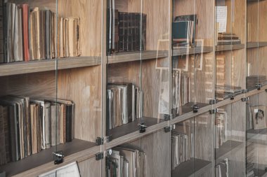 Tarihi kütüphanede cam kapılar ardında antika kitaplarla dolu bir kitaplık. Zaman içinde korunmuş nadir edebiyat koleksiyonu
