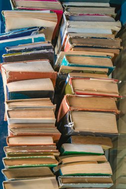 Bir yığın eski kitap. Yıpranmış kapaklı ve rahat kitapçıda sarı sayfaları olan bir yığın eski kitap. Edebiyat tarihi, entellektüel merak, ikinci el kitaplar.