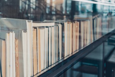 Eski kitaplarla dolu bir kitaplık ve camdaki yansımaları. Tarihi arşivde cam kutunun arkasında sergilenen antika kitaplar. Nadir bulunan el yazmalarının ve eski edebiyatın değerli bir koleksiyonu