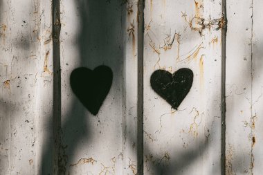 Kırık beyaz duvara boyalı iki siyah kalp şeklinde boya. Kalp grafitisi çürümeye zıt, aşkı simgeliyor, duyguyu.