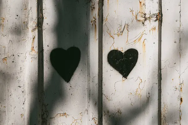 Kırık beyaz duvara boyalı iki siyah kalp şeklinde boya. Kalp grafitisi çürümeye zıt, aşkı simgeliyor, duyguyu.