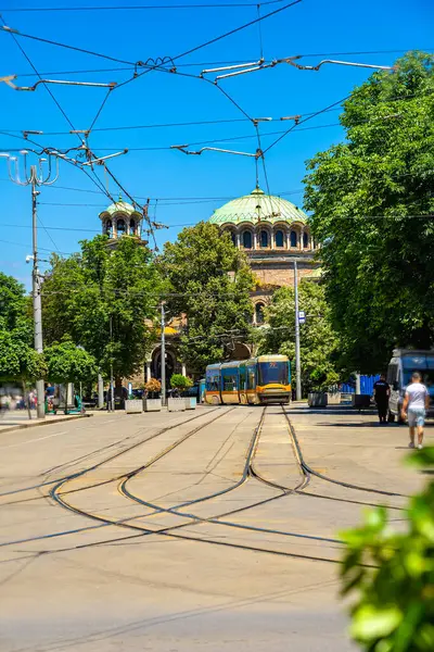 Sarı tramvay ve Kubbe Saint Nedelya Katedrali 'nin katedrali ile sokak manzarası, gelenek ve şehir hayatının karışımı, Sofya, Bulgaristan. Tramvay ve katedral şehir hareketini, kültürel mimari mirası birbirine bağlıyor