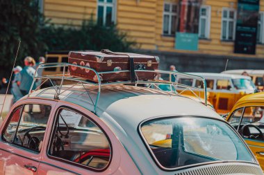 Çatı rafında antika bavulu olan eski model bir araba, nostaljik bir yolculuk. Bulgaristan 'ın Sofya kentinde Retro Araba Fuarı. Bavul ve araba birlikte seyahat atmosferi, özgürlük, nostaljik yolculuklar yaratıyor.