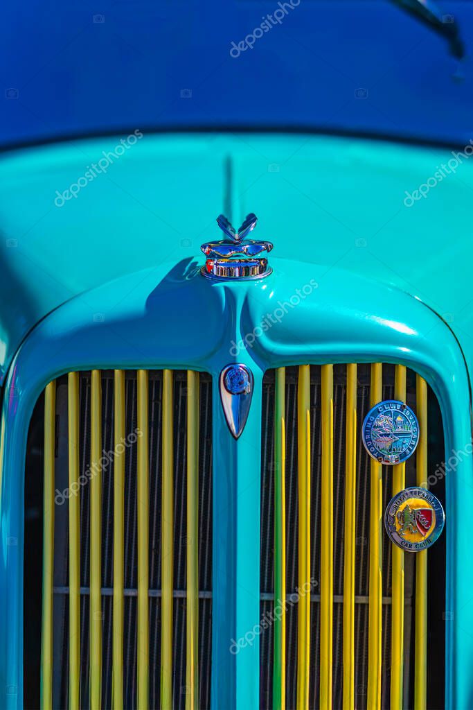 Close-up of classic blue Chrysler car hood with chrome mascot and grille badges. Car hood becomes retro symbol of style and club pride. Outdoor Retro Cars Exhibition in Sofia, Bulgaria