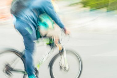 Kot elbiseli bir adam, çocuk koltuğunda bisiklet süren bir çocuk. Dinamik hareket bulanıklığı, modern hareketlilik, kentsel enerji. Sağlıklı yaşam tarzı, boş zaman konsepti
