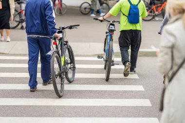 Yaya geçidinde bisikletle yürüyen insanlar. Şehir trafiği ve aktif yaşam tarzı. Şehir bisikleti, spor, bisiklet etkinliği, ulaşım kavramı