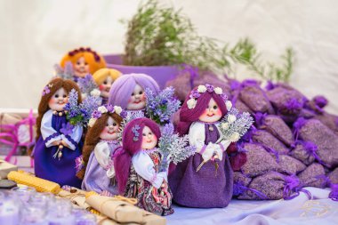 Lavanta bebekler ve hediyelik eşyalar. Markette lavanta temalı elbiseler içinde renkli el yapımı bebekler sergileniyor. Lavanta kavramı, el yapımı sanat, hediye fikirleri, yaratıcı dekor