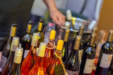 Arka planda şarap garsonuyla çeşitli şarap şişelerini kapatıyoruz. Etkinlik masasında içkileri düzenliyoruz. Festivalde şarap tatma, kutlama ve şarap servisi kavramı