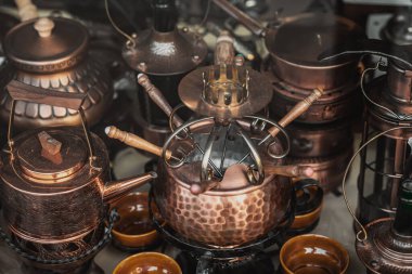 Bakır fondü seti ve Vintage Utensils. Ilık yansımaları ve dokuları olan zengin detaylarla donatılmış araçlar. Geleneksel zanaat kavramı, zamansız mutfak tarzı.