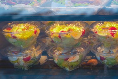 Plastik ambalajda sebze salataları hazırlayın. Yumuşak odaklanma. Taze sebze salataları buzdolabındaki plastik kaselerde servis ve paket servis için hazır. Sağlıklı beslenme kavramı, hareket halindeki yemek.