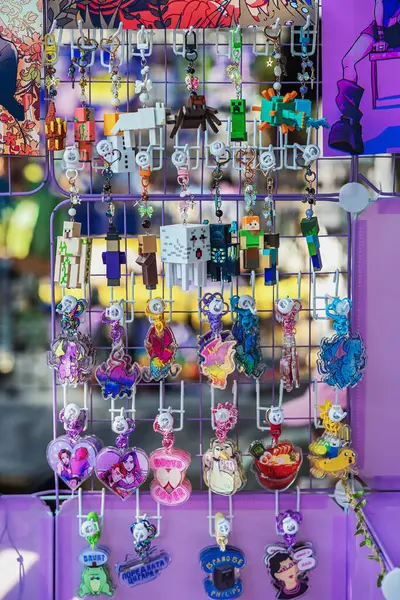 Minecraft Anahtarlığı, Sanat Standı. Şebeke paneli Minecraft temalı anahtarlıklar ve renkli fan akrilik büyüleriyle dolu. Oyun ürünleri kavramı, yaratıcı anahtarlık tasarımları