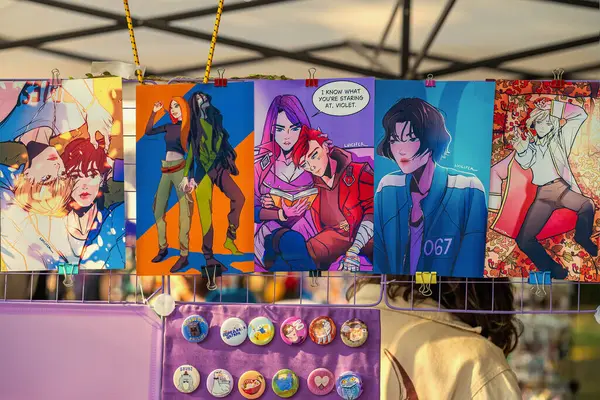 Orijinal karakterlerin renkli çizimleri canlı piyasa tezgahında düğme iğnelerinin üzerinde sergileniyordu. Bağımsız sanat anlayışı, hayran ifadesi, yaratıcı ürün anlayışı.