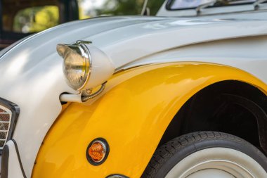 Baş lambası ve kanat Citroen. Klasik Citroen 2CV far ve ikonik yuvarlak dizaynlı sarı çamurluk. Antika araba tasarımı, eski otomobil detayları, koleksiyon çekici araç.