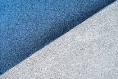 Mavi ve gri duvar yüzeyi geometrik çapraz çizgi oluşturuyor. Soyut kentsel minimalizm kavramı, modern arkaplan dokusu, renk kontrast kompozisyonu. Boşluğu kopyala