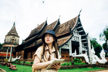 Tayland 'ın Chiang Mai bölgesindeki Ok Moli tapınağında tabletli Asyalı gezgin kadın.